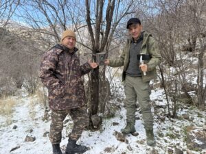 Scientific staff from Surkhan and Koytendag SNR pose next to a camera trap used to monitor wildlife - CLLC/Gabe Oppler